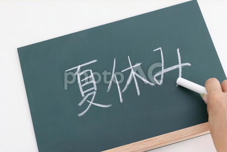 夏休みの文字を黒板に書く手元 黒板,夏休み,手書きの写真素材