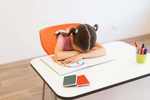 机に伏せて寝る女の子 女の子,子ども,人物の写真素材