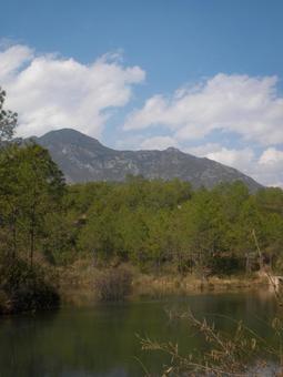 青空と山並みが映える静かな湖畔の写真