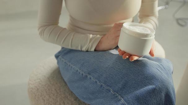 屋内でクリームを持っている女性 屋内でクリームを持っている女性の写真