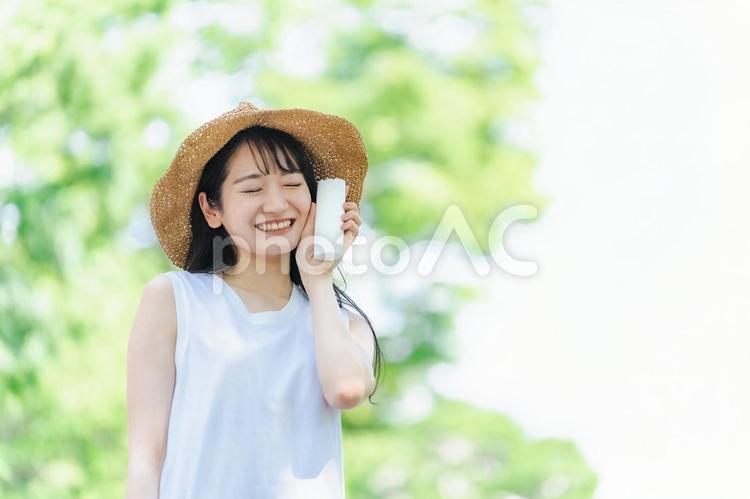 夏に麦わら帽子を被る女性（日焼け止め） 夏,スキンケア,日焼け止めの写真素材