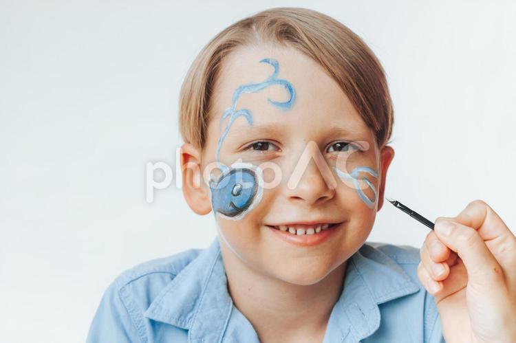 カメラ目線でフェイスペイント中の男の子 男の子,フェイスペイント,笑顔の写真素材