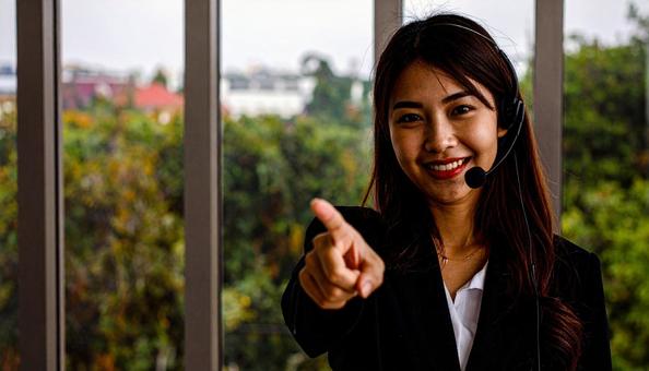 ヘッドセットをつけカメラ目線で笑顔の女性の写真