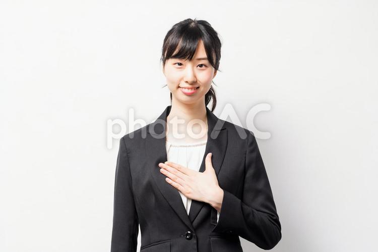 胸に手を当てて、想いを伝える若いビジネスウーマン 胸,手,若いの写真素材