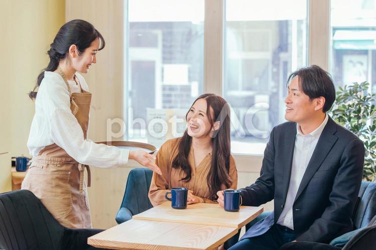 カフェにきた男女とホールスタッフ カフェ,コーヒー,コーヒーショップの写真素材