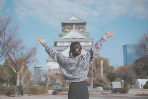 大阪城と喜ぶ女性旅行者の後ろ姿 大阪城と喜ぶ女性旅行者の後ろ姿の写真