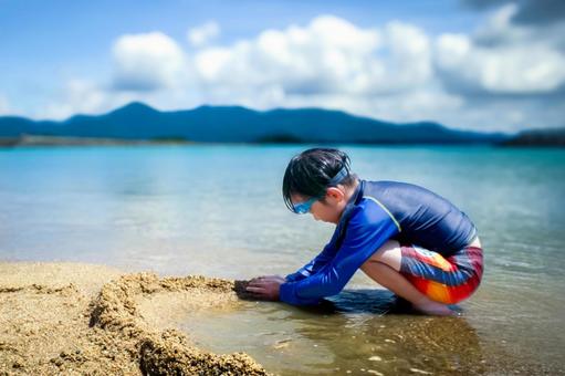<素材>海へ泳ぎにきて砂遊びをする男の子 <素材>海へ泳ぎにきて砂遊びをする男の子 子供,男性,人物の写真素材
