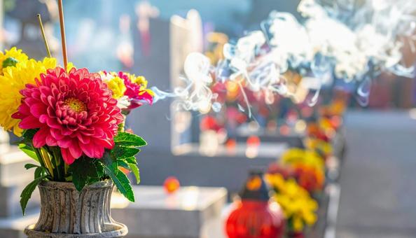 祖先を供養するための花と線香の煙の写真