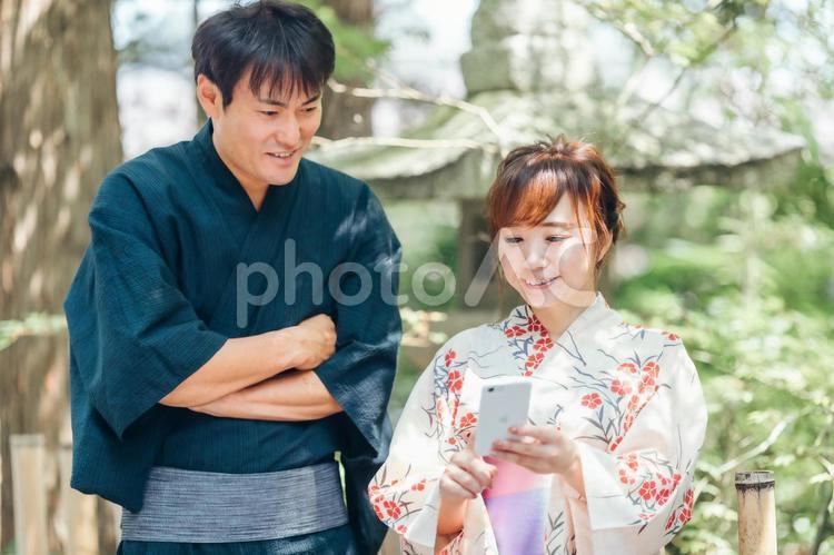 スマホを持つ浴衣姿の男女 浴衣,アプリ,カップルの写真素材