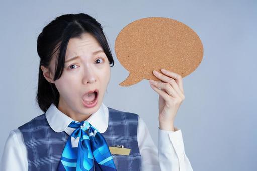 青いリボンの制服の女性が吹き出しをもって驚く 女性,吹き出し,持つの写真素材