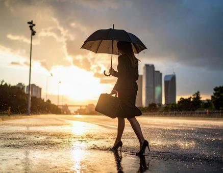 濡れた路面を歩くビジネスウーマン 濡れた路面を歩くビジネスウーマンの写真