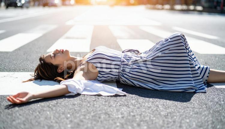 暑さでダウンし、路上に倒れる女性 ダウン,倒れた,女性の写真素材