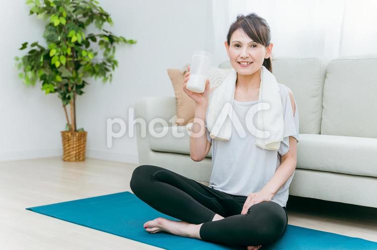 部屋でプロテインを飲むミドル世代の女性 プロテイン,タンパク質,ヨガの写真素材