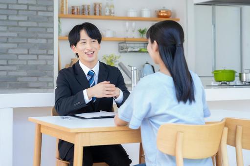 リビングで女性と商談をするビジネスマン リビングで女性と商談をするビジネスマン 営業,金融,保険の写真素材