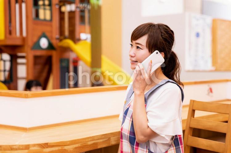スマホを使う保育士／託児所／ママ 保育士,託児所,主婦の写真素材