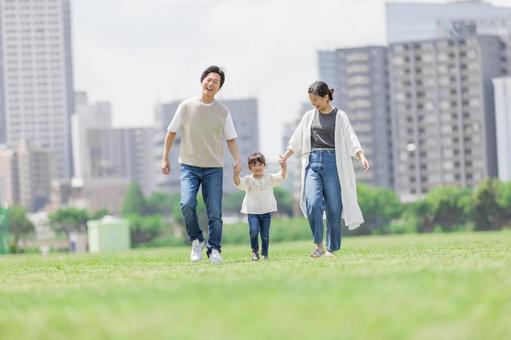 手を繋いで屋外を散歩する親子 手を繋いで屋外を散歩する親子 人物,家族,女性の写真素材