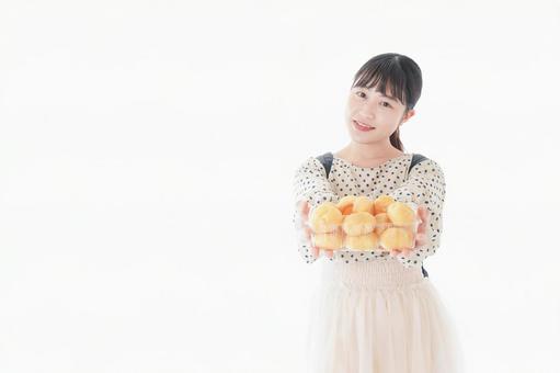 おやつを食べる若い女性 おやつを食べる若い女性の写真