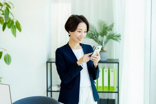 スマホを持つビジネスウーマン スマホを持つビジネスウーマン スマホ,ビジネスウーマン,キャリアウーマンの写真素材