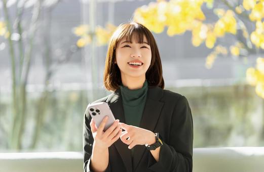 秋のオフィスでスマホを使う女性 秋のオフィスでスマホを使う女性 女性,秋,紅葉の写真素材