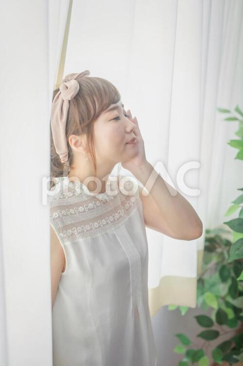 頬に手を当ててスキンケア効果を確かめている女性 美白,透明感,美肌の写真素材