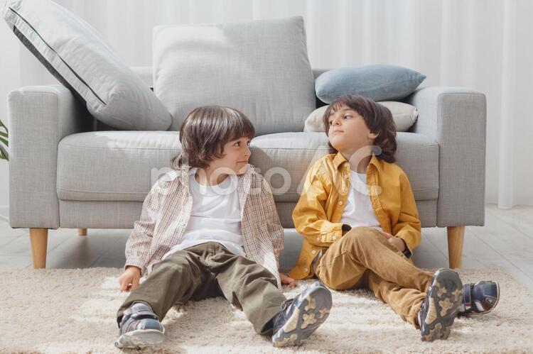 ソファーの前に座る双子の男の子 双子,兄弟,男の子の写真素材