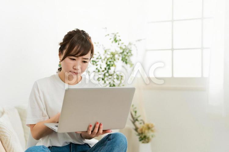 ソファでパソコンを見て困る日本人女性 パソコン,女性,困るの写真素材