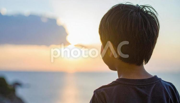 夕焼けの空を見つめる日本人の少年 ビジョン,将来,子供の写真素材