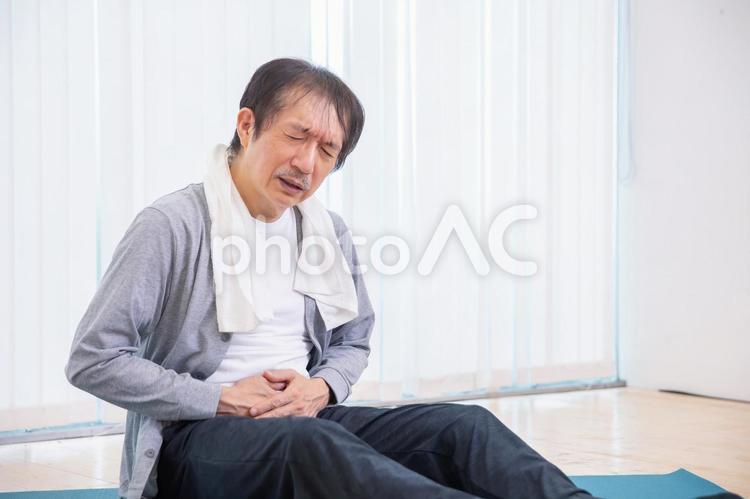 トレーニング中に痛がる中高年男性（腹痛） 腹痛,お腹,痛いの写真素材