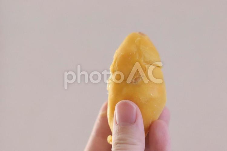 一粒のドリアンを手でつまむ様子 ドリアン,南国フルーツ,トロピカルフルーツの写真素材