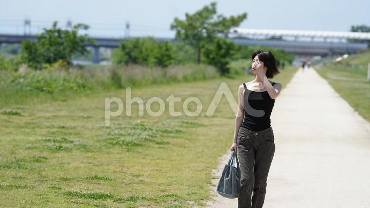 真夏の公園を歩く女性 女性,キャミソール,若い女性２０代の写真素材