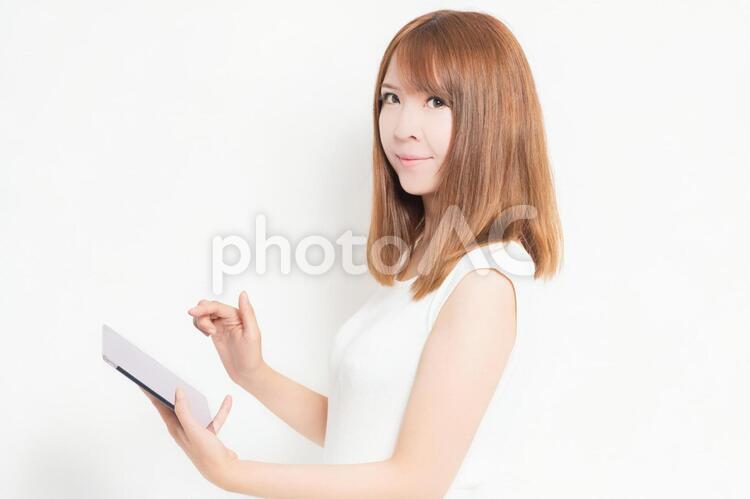 タブレット端末を使うワンピースを着た女性 女性,タブレット,snsの写真素材