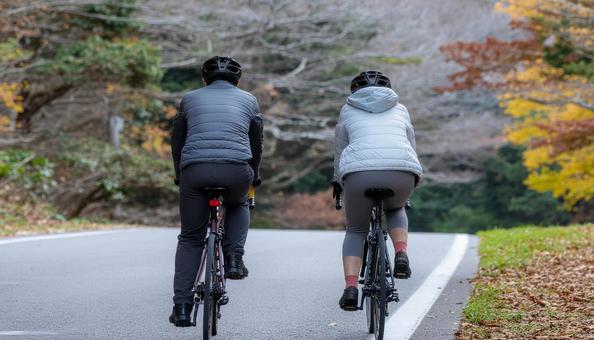 ロードバイクでサイクリングする男女 ロードバイクでサイクリングする男女の写真