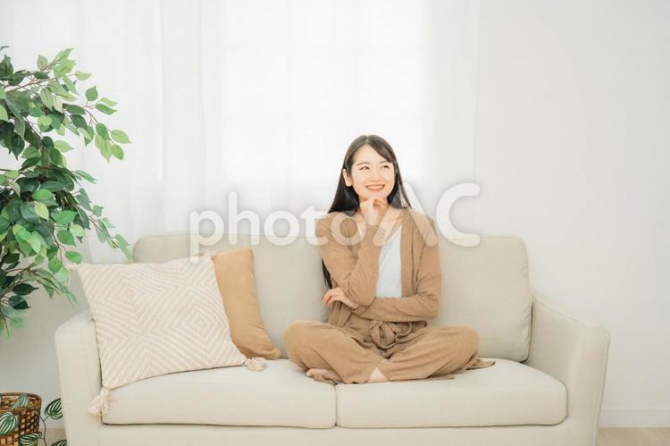 家のソファに座る女性 リビング,女性,ソファの写真素材