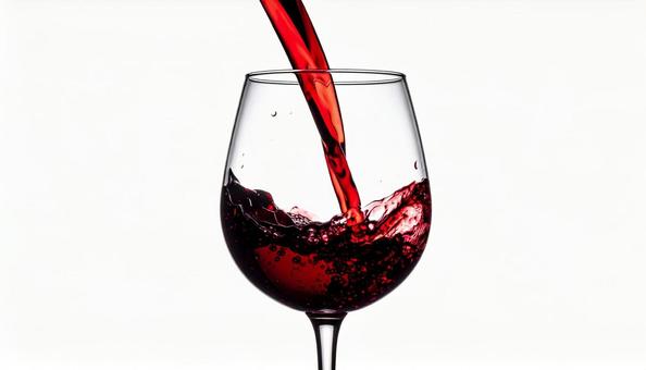 赤ワインを注がれているワイングラスの写真