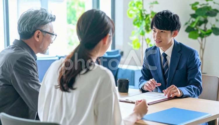男性営業マンの説明を聞く親子 男性,営業マン,説明の写真素材