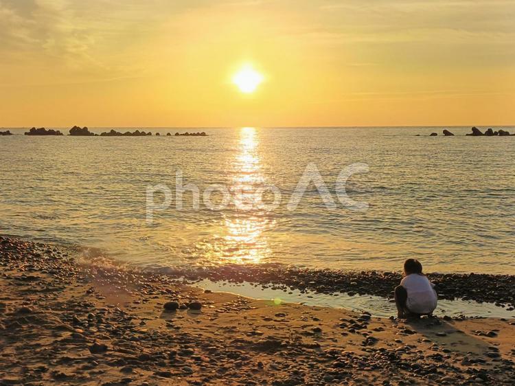 夕陽と海辺で遊ぶ女の子 日本海,海,夕陽の写真素材