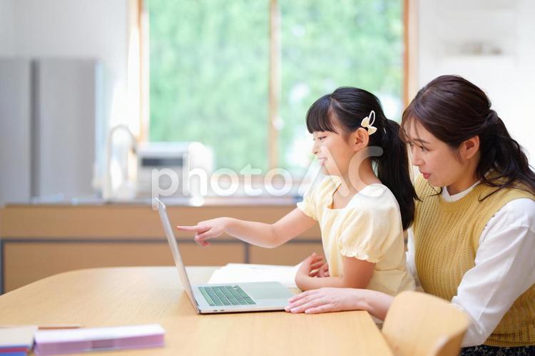 画面をタッチしようとしている女の子 母,娘,ノートパソコンの写真素材