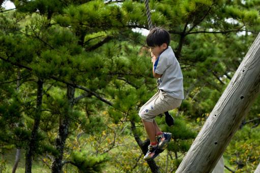 <素材>公園のターザンロープで遊ぶ少年 <素材>公園のターザンロープで遊ぶ少年 子供,ターザンロープ,遊具の写真素材