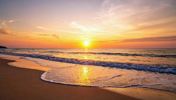 海に沈む夕日・夕焼けに照らされる海岸線 海に沈む夕日・夕焼けに照らされる海岸線の写真