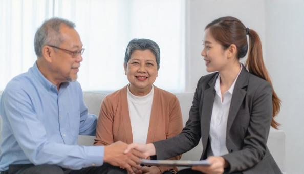 シニア夫婦と契約するビジネスウーマン　の写真