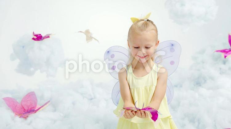 笑顔で蝶の飾りを持つ女の子 女の子,蝶,ピンクの写真素材