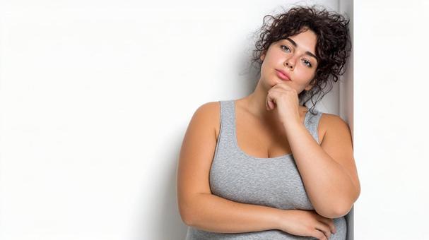 考えるポーズをとるグラマラスな女性の写真