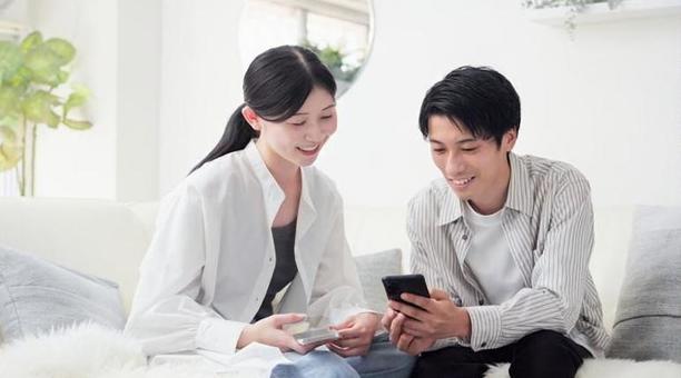 笑顔でスマホを見るアジア人カップル 笑顔でスマホを見るアジア人カップル スマートフォン,スマホ,見るの写真素材