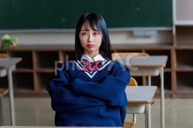 腕を組んで見つめてくる女子高生 女子高校生,高校生,女子高生の写真素材