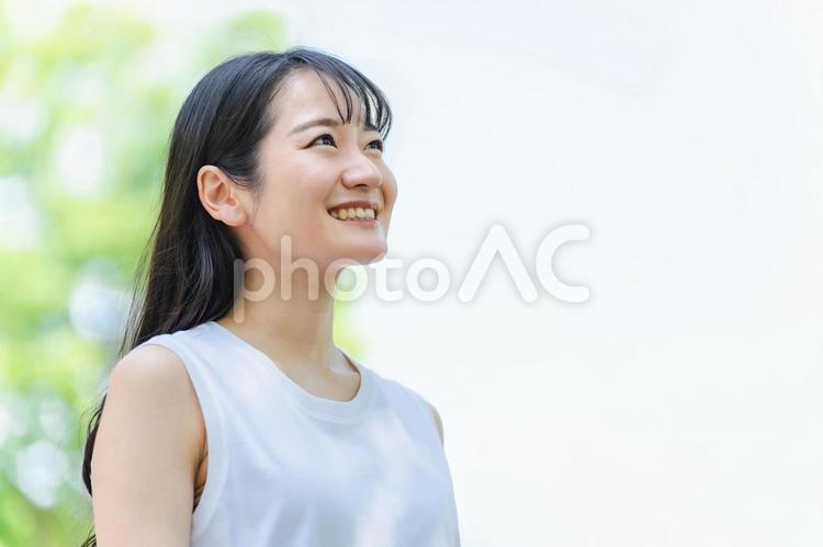 緑の中にいる女性（笑顔・青空） 美容,スキンケア,女性の写真素材