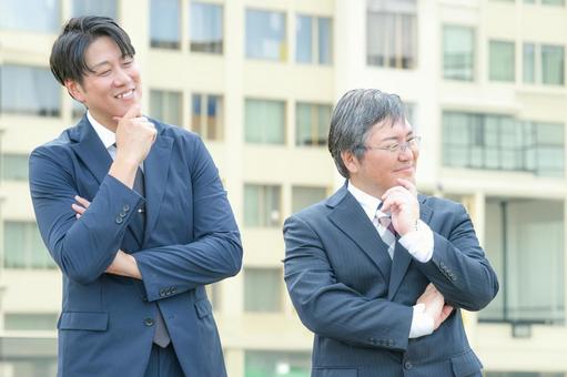 考えるビジネスマン達 考えるビジネスマン達 男性,スーツ,屋外の写真素材