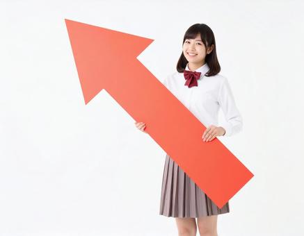 上向きの矢印を持つ女子生徒 上向きの矢印を持つ女子生徒の写真