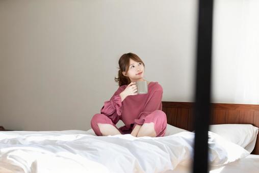 寝室でくつろぐ女性 寝室でくつろぐ女性の写真