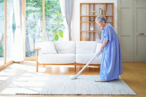 ラグの掃除をする横向き女性 女性,掃除,掃除機の写真素材