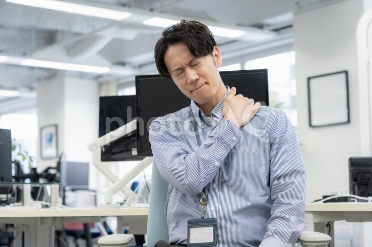 体調の悪い若い男性エンジニア ビジネス,オフィス,肩こりの写真素材